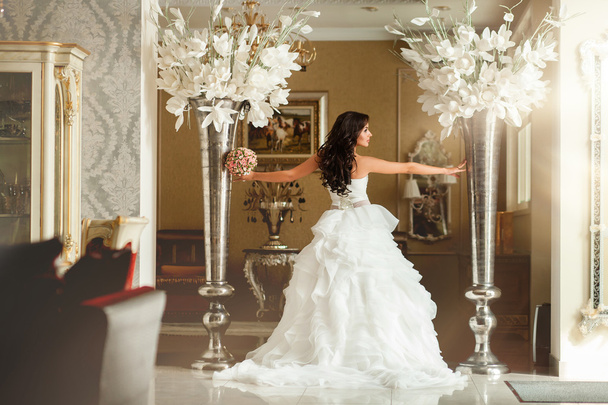 Bride in white wedding dress with big flowers - Fotó, kép