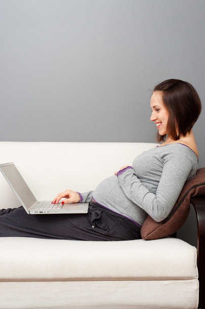 Smiley zwangere vrouw met laptop - Foto, afbeelding