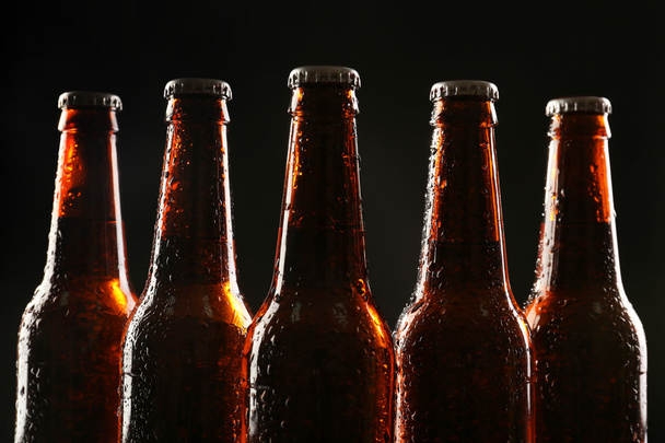 Glass bottles of beer on dark background - Foto, imagen