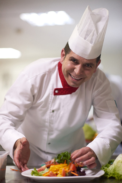 chef en cocina preparando y decorando alimentos
 - Foto, Imagen
