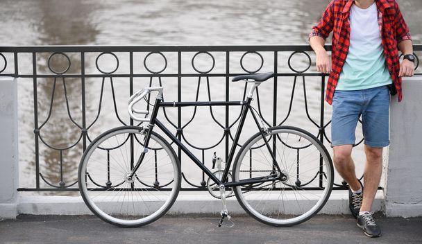 Hipster homem com bicicleta descansando sobre cais
 - Foto, Imagem