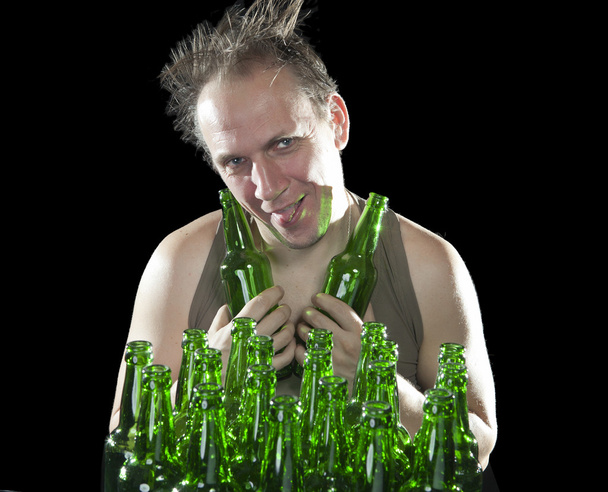 The happy tipsy man near empty beer bottles - Foto, imagen