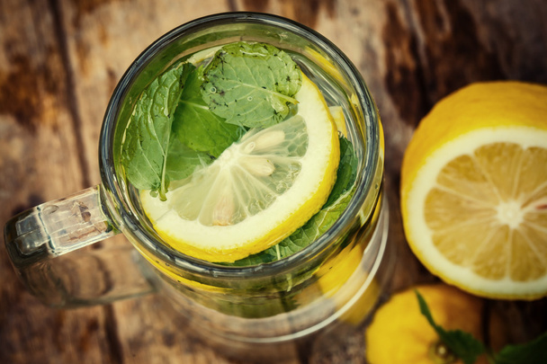 Water with lemon and mint on a wooden board - Photo, Image
