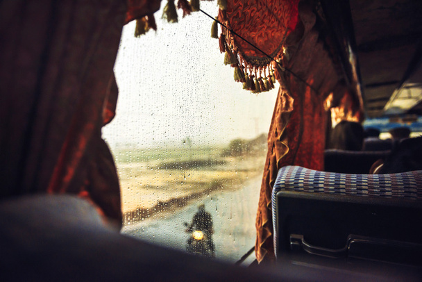 Πολλαπλών σταγόνες του νερού σε ένα παράθυρο λεωφορείο, στο δρόμο για Πνομ Pe - Φωτογραφία, εικόνα