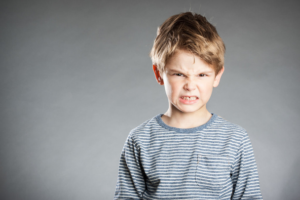 Portrait of boy, emotion, angry, grey background - Фото, изображение