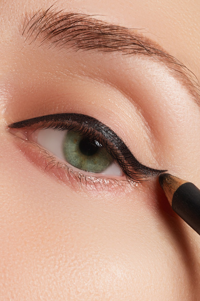 Beautiful model applying eyeliner closeup on eye - Photo, Image