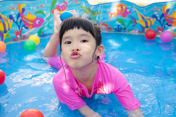 Дитяча дівчинка грає в басейні
 - Фото, зображення