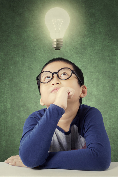 Clever little boy with a bright light bulb - Foto, imagen