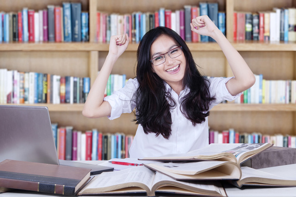 Teenage girl expressing happy in the library - 写真・画像
