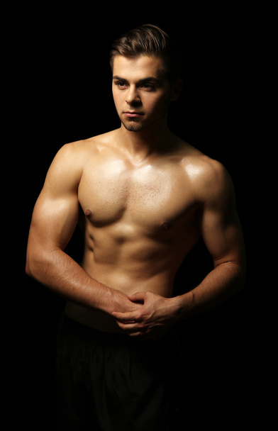 Muscle young man on dark background - Foto, Imagen