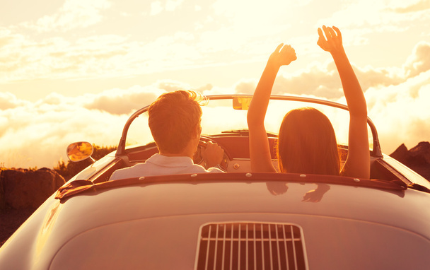 Young Couple Wathcing the Sunset in Vintage Sports Car - Foto, immagini