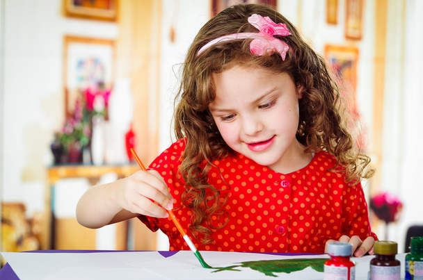 Happy little artistic girl painting - 写真・画像