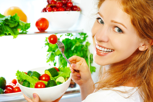 mujer come comida saludable vegetal ensalada vegetariana sobre refrige
 - Foto, imagen