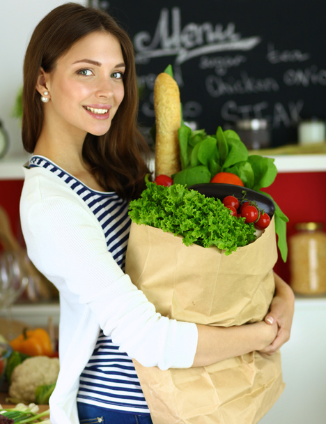 Fiatal nő gazdaság élelmiszerbolt bevásárló táska zöldségekkel  - Fotó, kép