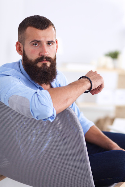 Young businessman sitting on chair in office - Photo, Image