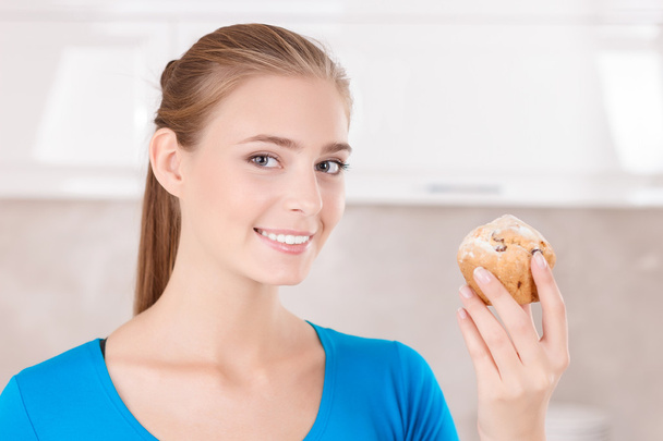 Upbeat girl holding muffin  - Foto, afbeelding