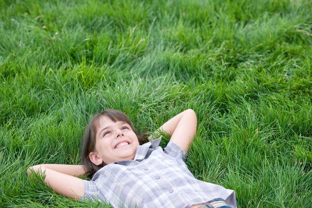 щаслива дівчина лежить на траві
 - Фото, зображення