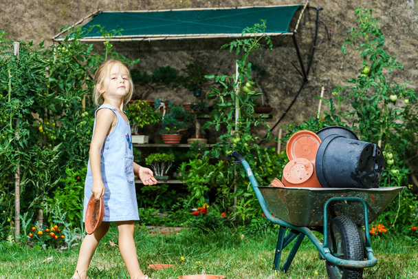 Schattig klein meisje helpen haar moeder in de achtertuin - Foto, afbeelding