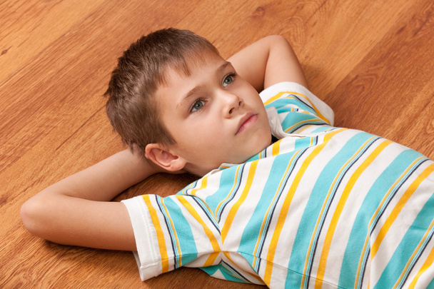 Retrato de um menino pensativo com grandes olhos cinzentos deitado no woo
 - Foto, Imagem