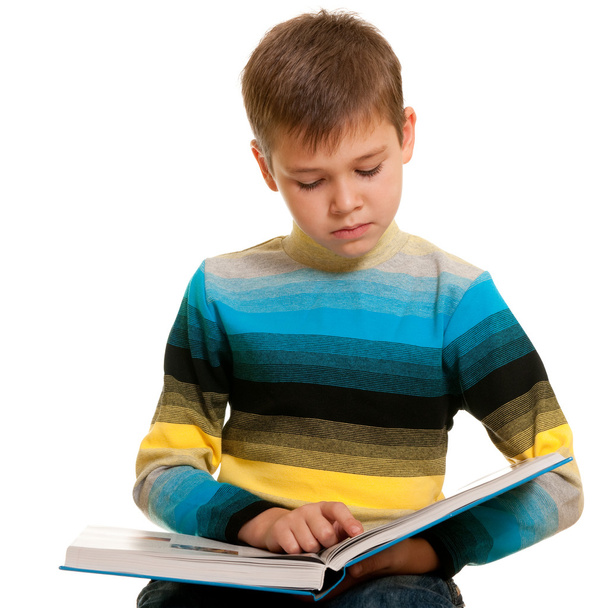 aufmerksamer schlanker Junge liest ein dickes Buch - Foto, Bild