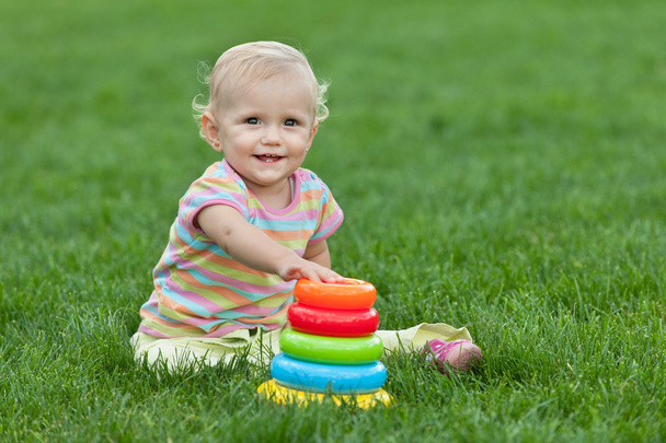 Улыбающаяся маленькая девочка с игрушечной пирамидой
 - Фото, изображение