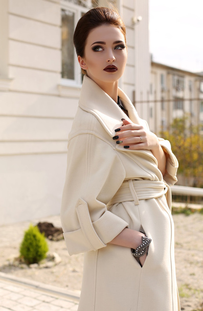 beautiful woman with dark hair in elegant beige coat - 写真・画像