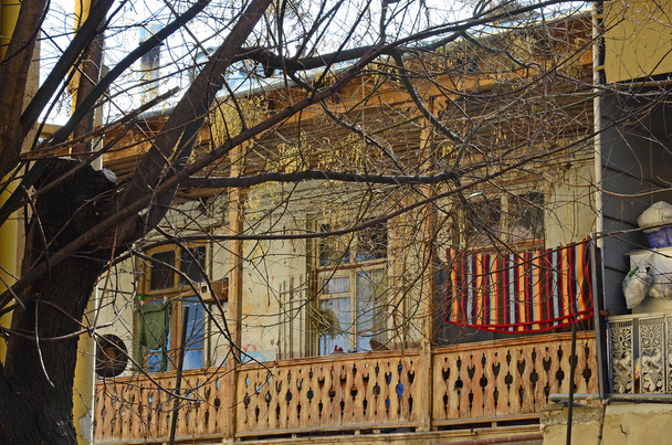 Old wooden balcony with a bright mat on the rope. Tbilisi, Georgia - Photo, Image