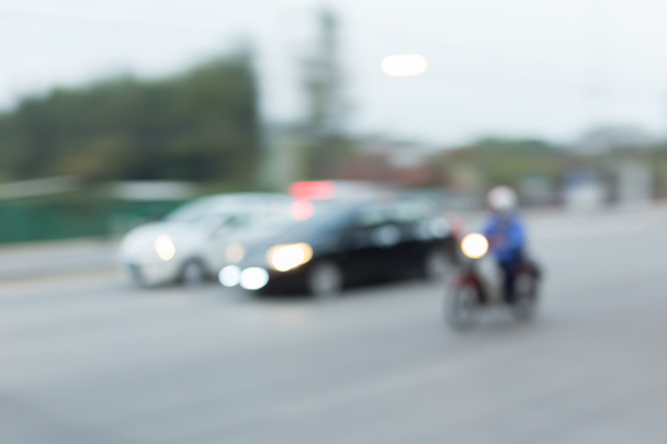 Автомобиль и мотоцикл едут по дороге с пробки в городе
 - Фото, изображение