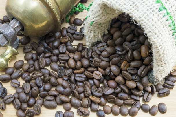 Koffiebonen vallen uit koffie zak naast een vintage koffie gr - Foto, afbeelding