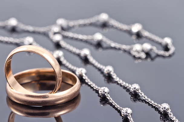 Golden wedding rings and elegant silver chain - Zdjęcie, obraz