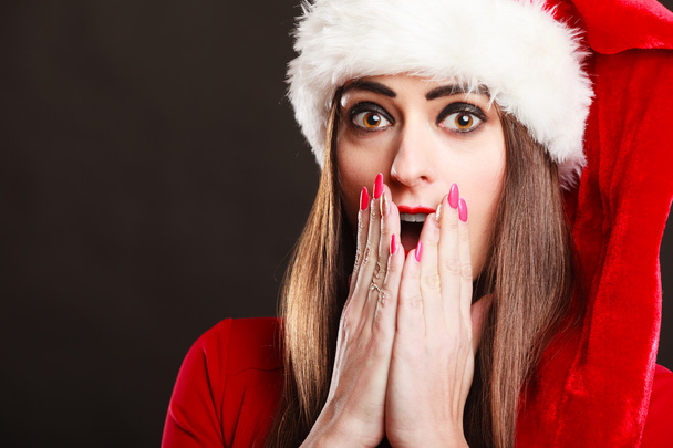 Surprised woman wearing santa claus hat - Fotografie, Obrázek