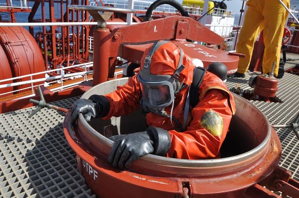 hombre en traje químico que entra dentro del tanque de carga en el petrolero químico para la operación de limpieza
 - Foto, Imagen