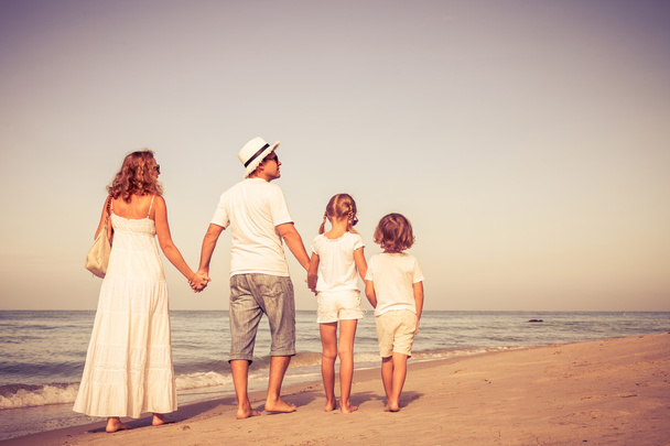 gelukkige familie wandelen op het strand op het moment van de dag. - Foto, afbeelding