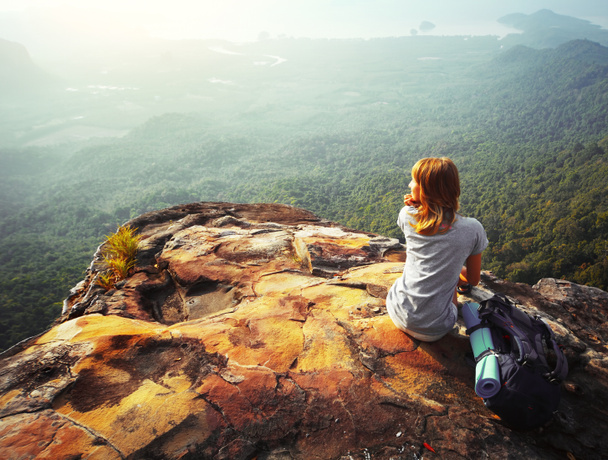 fiatal nő ül egy sziklán - Fotó, kép