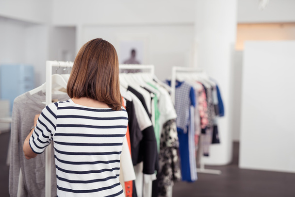 Жінка шукає одяг у магазині
 - Фото, зображення