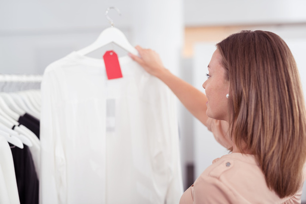 Woman Looking at White Shirt Inside a Store - Фото, зображення