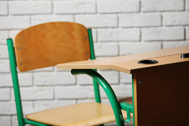 School desk and chair on white brick wall background - Photo, image