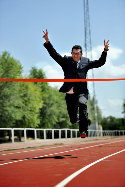 бизнесмен, бегущий по спортивной трассе, празднуя победу в концепции успеха на работе
 - Фото, изображение