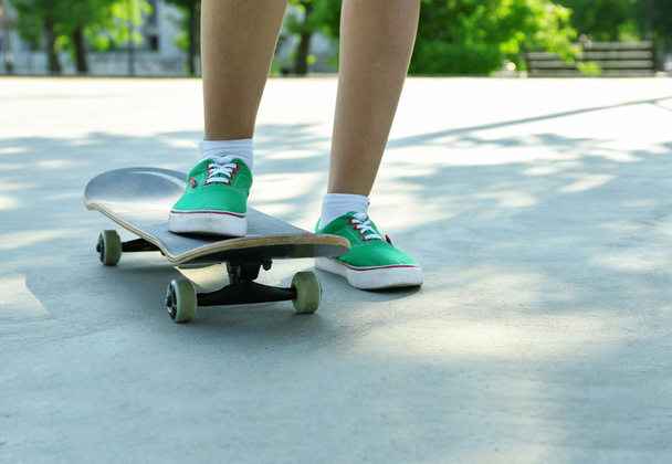 Young skateboarder in gumshoes standing on skate - Fotografie, Obrázek