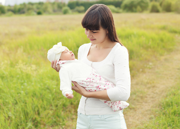 Portrait of happy young mother walking with infant outdoors on t - Foto, Imagem