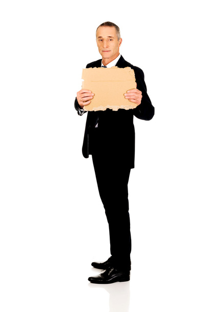 Businessman holding a piece of cardboard - Photo, Image