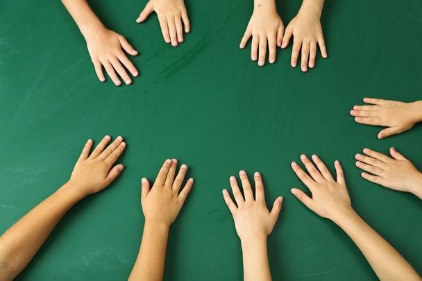 Children hands on blackboard background - Zdjęcie, obraz