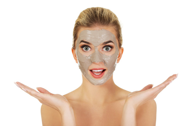 Young surprised woman with facial mask - Foto, imagen