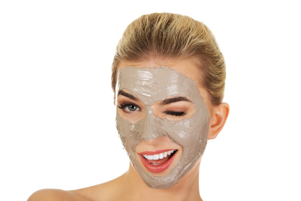Young happy woman with facial mask. - Foto, afbeelding