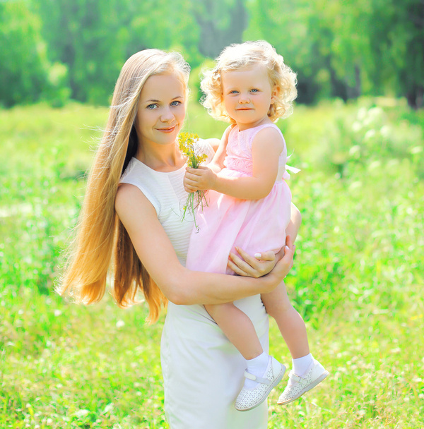 Sunny portrait of happy mother and child wearing a dress togethe - Foto, Imagen
