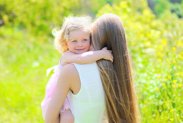 Retrato soleado de un niño feliz abrazando a la madre en el día de verano
 - Foto, Imagen