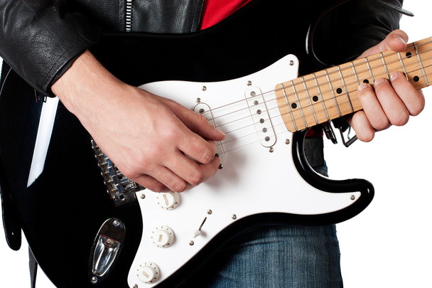 Young guy in leather jacket playing electric guitar - Photo, Image