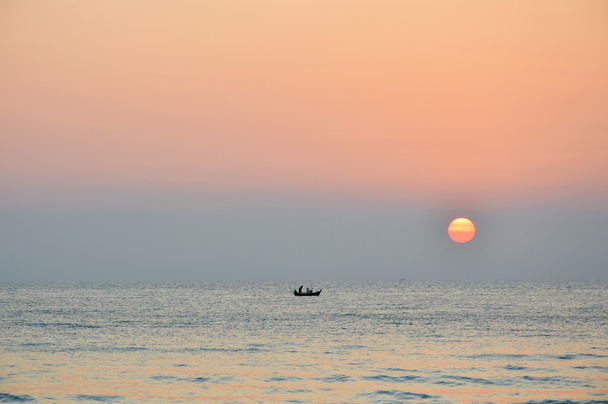 Fischerboot bei Sonnenaufgang im Meer - Foto, Bild