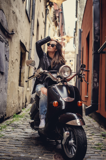 lässige junge Frau sitzt auf Motorroller. - Foto, Bild