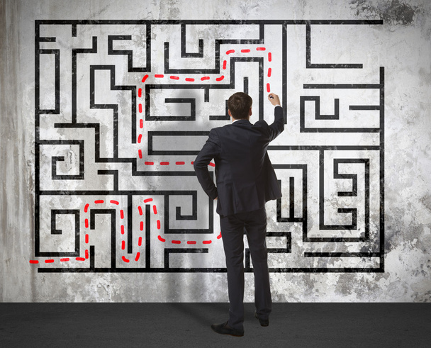 Businessman drawing labyrinth on wall - Foto, afbeelding